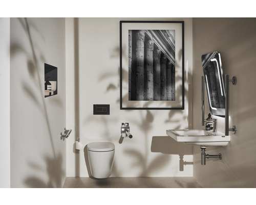 Salle de bains lumineuse avec WC suspendu, lavabo, miroir et tableau encadré