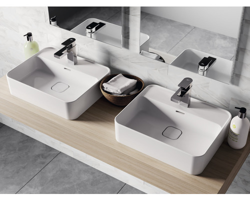 Salle de bains avec deux vasques à poser blanches, robinetteries et miroir