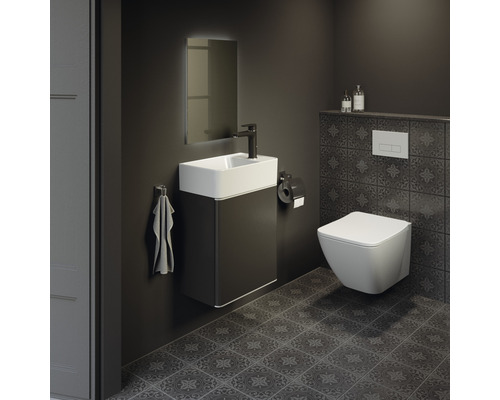 Modernes Badezimmer mit Waschtisch, Spiegel, Toilette und dunklen Fliesen.