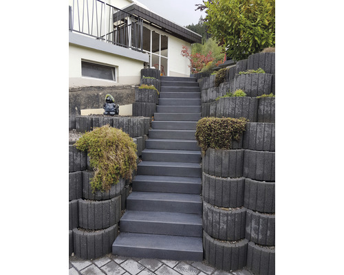 Escalier en béton menant à la maison à travers une pente plantée