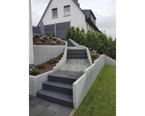Escaliers avec marches et murs dans le jardin devant une maison.