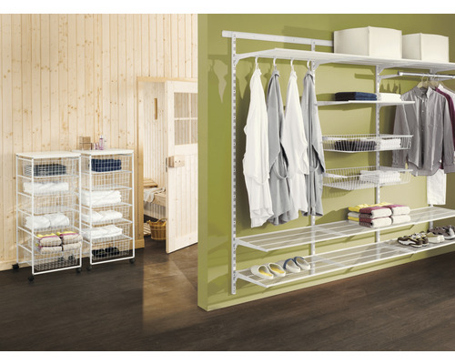 Ankleideszene mit einem modularen Regalsystem und fahrbaren Drahtkörben zur Aufbewahrung von Textilien.