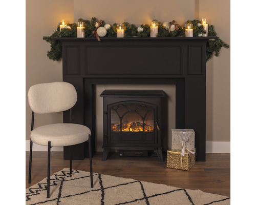 Cheminée décorative avec décoration, cadeaux, fauteuil et tapis dans un salon