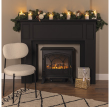 Intérieur décoratif avec cheminée électrique, chaise, tapis et décorations de Noël