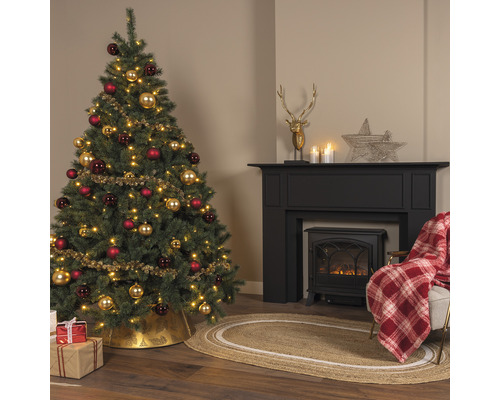 Sapin de Noël décoré pour les fêtes à côté d''une cheminée dans un salon