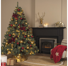 Sapin de Noël avec décorations de Noël rouges et dorées dans un salon avec cheminée