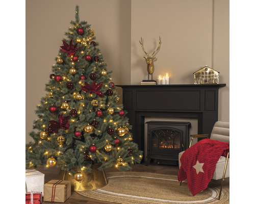 Weihnachtliche Wohnzimmerszene mit geschmücktem Tannenbaum, Kamin und Dekoration