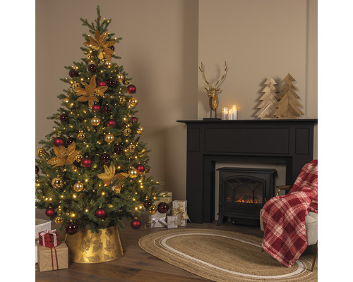 Pièce décorée pour Noël avec sapin, cheminée et cadeaux.