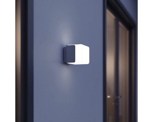 Quadratische Wandleuchte an einer Wand neben einer Tür