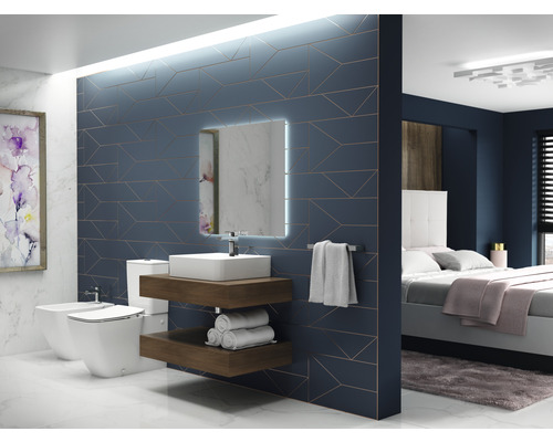 Badezimmer mit Toilette, Bidet, Waschbecken, Spiegel und Schlafzimmer mit Bett im Hintergrund