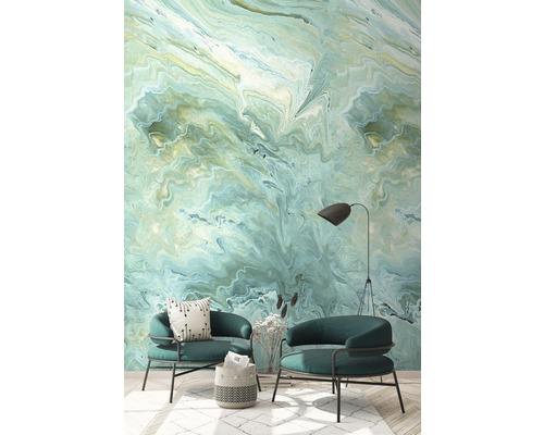 Salon avec deux fauteuils et un revêtement mural aspect marbre