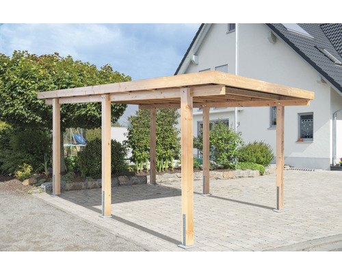 Holzcarport vor einem Wohnhaus mit gepflasterter Einfahrt