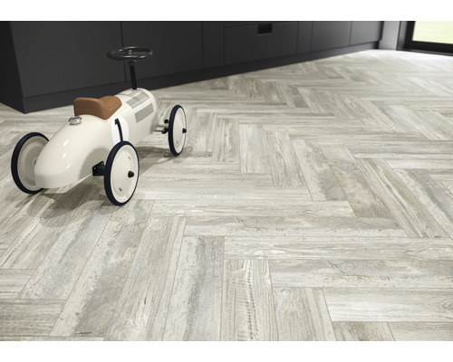 Boden mit hellen Fliesen im Fischgrätmuster und Spielzeugauto