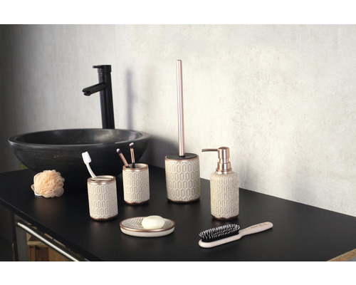 Salle de bain avec lavabo et divers accessoires de salle de bain, dont un distributeur de savon, un porte-brosse à dents, un porte-savon et une brosse de toilette