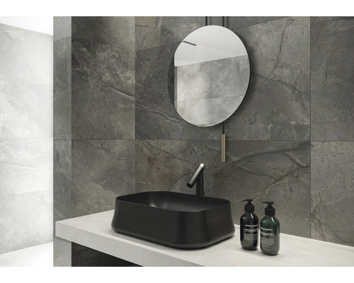 Salle de bain moderne avec lavabo à poser, miroir et carreaux muraux gris aspect marbre.