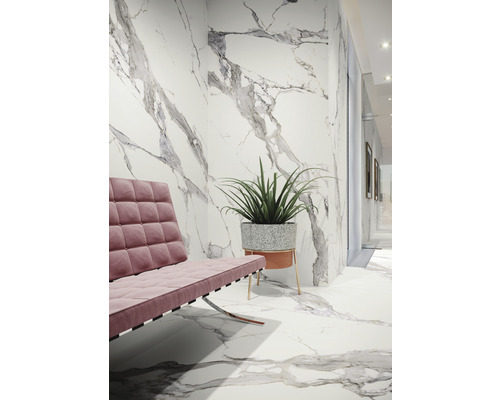 Heller Raum mit Wand- und Bodenfliesen in Marmoroptik, Sitzgelegenheit und Topfpflanze.