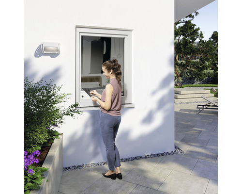 Femme actionne la fenêtre avec une tablette à l''extérieur