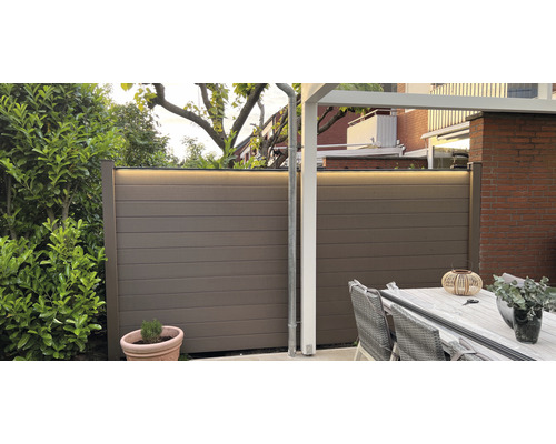 Gartenszene mit braunem Sichtschutzzaun mit LED-Beleuchtung