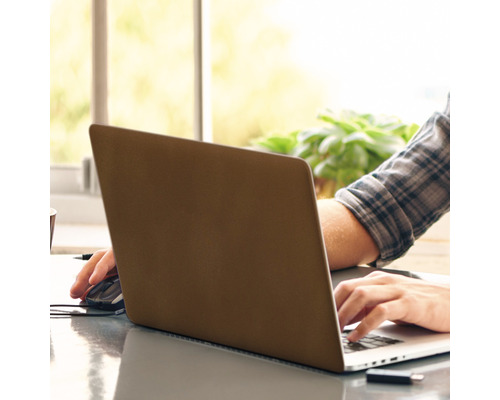 Une personne travaille sur un ordinateur portable avec une souris sur une table.