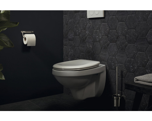 Salle de bains moderne avec WC suspendu, porte-papier toilette et carrelage hexagonal