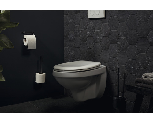 Salle de bains moderne avec WC suspendu, porte-papier toilette et carrelage hexagonal