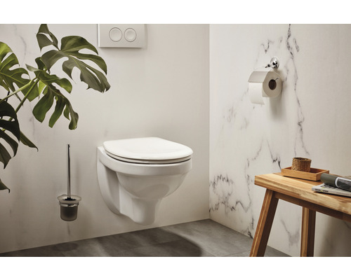 Modernes Badezimmer mit wandhängendem WC, Toilettenbürste, Papierhalter und Dekoration.