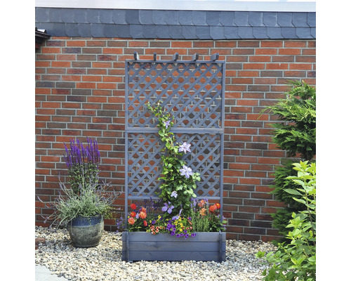 Trellis en bois avec jardinière devant un mur de briques