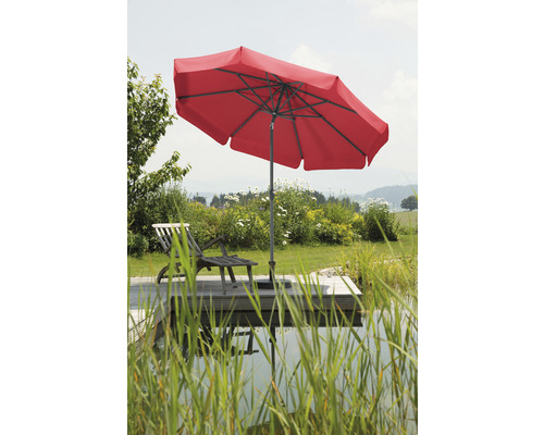 Parasol rouge à côté d''une chaise longue dans le jardin