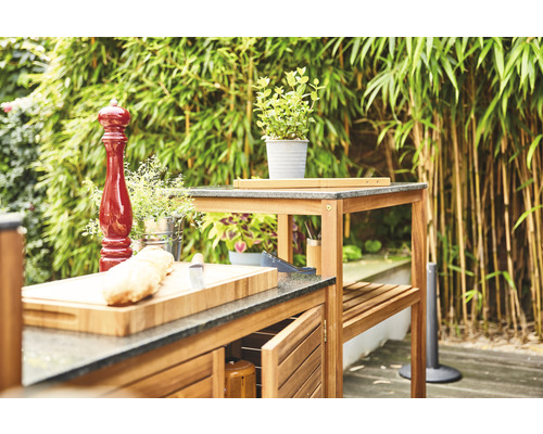 Cuisine extérieure avec plans de travail, armoires et étagères sur fond naturel.