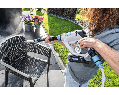 Frau reinigt einen Stuhl mit einem Gloria Hochdruckreiniger im Außenbereich