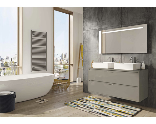 Badezimmer mit Badewanne, Waschtisch mit zwei Waschbecken und beheiztem Handtuchhalter für ein helles und geräumiges Ambiente