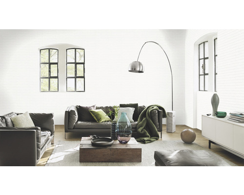 Salon lumineux avec canapé en cuir et papier peint à motifs en aspect pierre