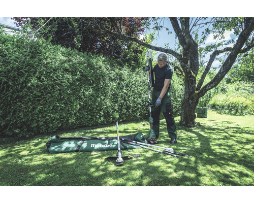 Un homme assemble un outil multifonction Metabo dans le jardin.