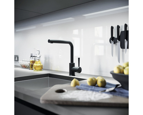 Moderne Küche mit schwarzem Wasserhahn, Spüle und Küchenutensilien
