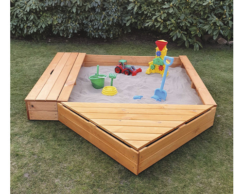 Bac à sable en bois avec jouets dans le jardin