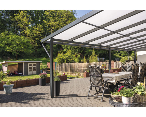 Überdachte Terrasse mit Gartentisch, Stühlen und Pflanzen