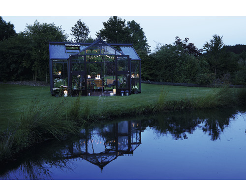 Serre avec table à manger et éclairage dans le jardin