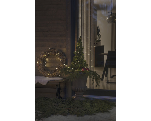Véranda décorée avec couronne, arbre illuminé et jardinière