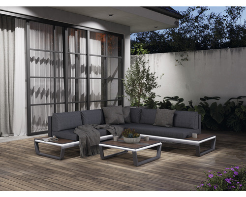 Terrasse mit Lounge-Ecke, bestehend aus Sofa, Kissen, Couchtisch und dekorativen Elementen.