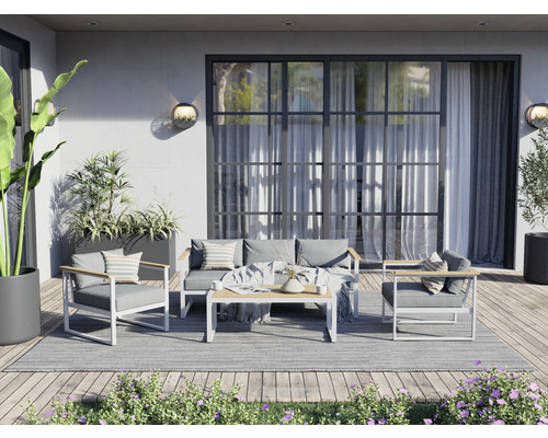 Terrasse avec salon de jardin comprenant un canapé, des fauteuils et une table sur un tapis