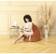 Femme assise sur un pouf dans le salon
