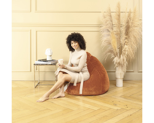 Femme assise sur un pouf dans le salon