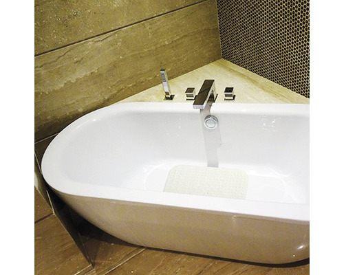 Freistehende Badewanne mit Armatur in einem Badezimmer mit Fliesen