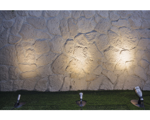 Beleuchtete Steinwand mit Gartenleuchten