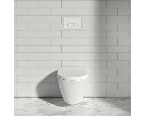 WC suspendu avec plaque de commande devant un mur carrelé