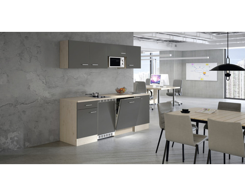 Cuisine de bureau avec lave-vaisselle, micro-ondes et table à manger dans un bureau lumineux.