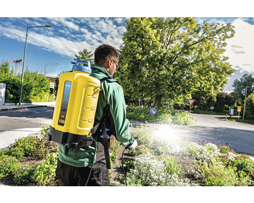 Un homme utilise un pulvérisateur à dos Gloria pour l''entretien du jardin.