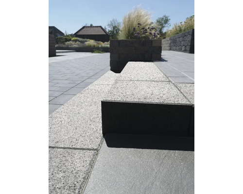 Außenbereich mit Pflastersteinen und erhöhten Pflanzkästen