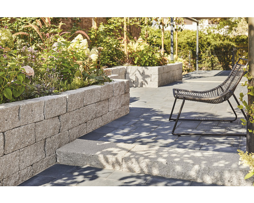 Garten mit Rasenfläche, Gartenmöbeln und Hochbeet aus Steinen