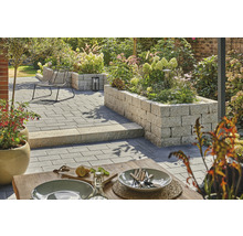 Jardin aménagé avec pavés, coin salon et plates-bandes surélevées